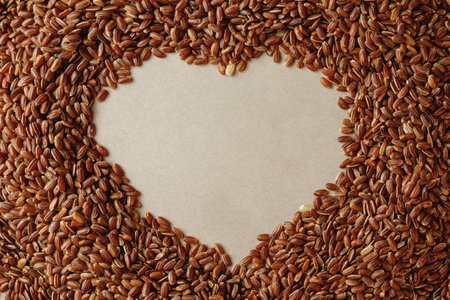 Heart-shaped arrangement of organic brown rice creating an artistic displayの写真素材