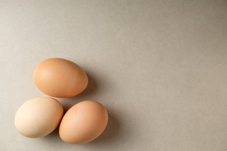 Fresh eggs resting on a smooth surface add warmth to the kitchen settingの写真素材