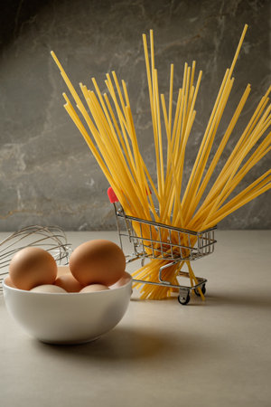 Fresh eggs and pasta create a culinary scene in a cozy kitchenの写真素材