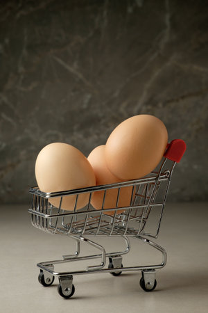 Unique grocery shopping with eggs in a tiny cart for a culinary adventureの写真素材
