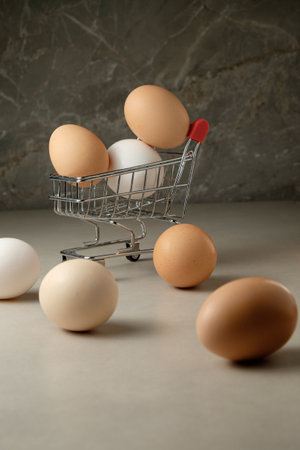Unique shopping moment with eggs in a mini cart on a smooth surfaceの写真素材