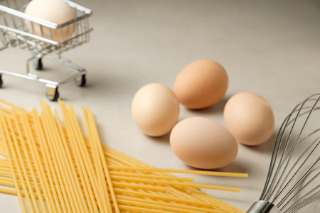 Creative cooking setup with eggs and pasta in a kitchen environmentの写真素材