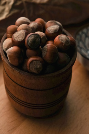 Delicious hazelnuts in a rustic wooden bowl on a cozy kitchen tableの写真素材