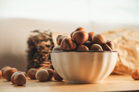 Freshly harvested hazelnuts in a rustic bowl on a wooden table