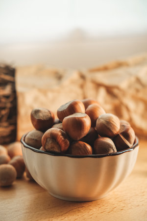 Bowl of fresh hazelnuts surrounded by rustic natural decorの写真素材