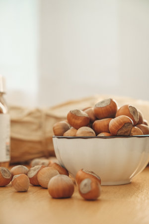 Fresh hazelnuts arranged in a bowl with a rustic backgroundの写真素材