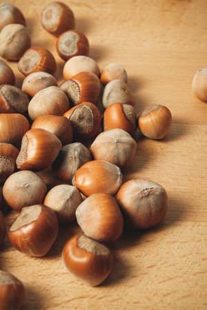 Hazelnuts spread on a wooden table, highlighting their rich colorsの写真素材