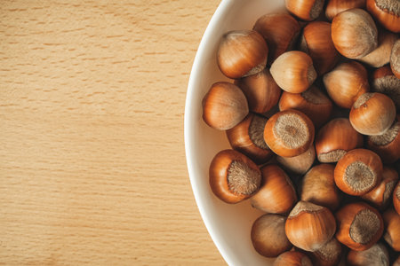 Freshly harvested hazelnuts in a rustic bowl on a wooden table