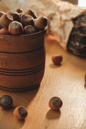Freshly harvested hazelnuts in a rustic wooden bowl on a sunlit table