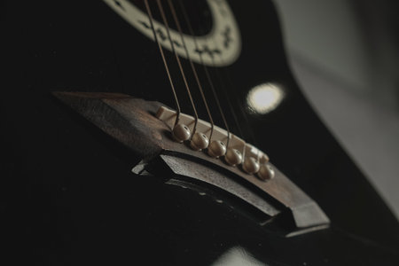 Strings resonate in harmony from a polished black guitar bodyの写真素材
