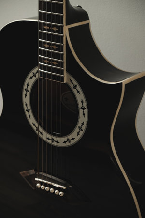 Beautiful black acoustic guitar showcased against a simple backgroundの写真素材