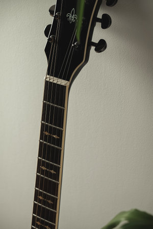 Guitar neck gently illuminated against a soft white backgroundの写真素材