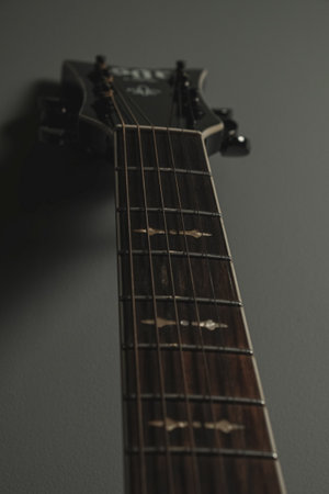 Unique perspective of a guitar captured against a dark backgroundの写真素材