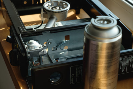 Cooking stove parts laid out for maintenance in a cozy kitchen settingの写真素材