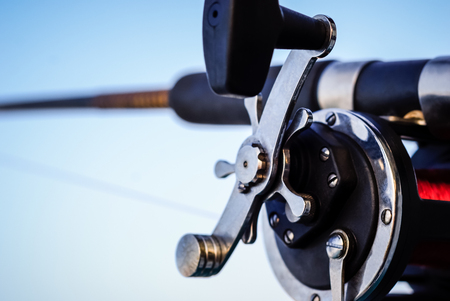 Picture of a fishing pole and reel under a blue skyの写真素材