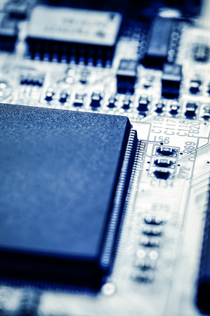 Picture of a computer circuit board chips macro blue tinted.
