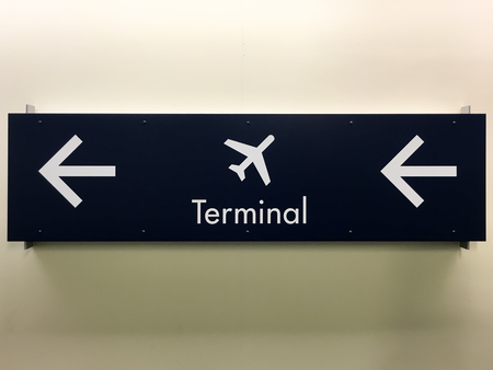 Airport Terminal Arrow Sign on a Wallの写真素材