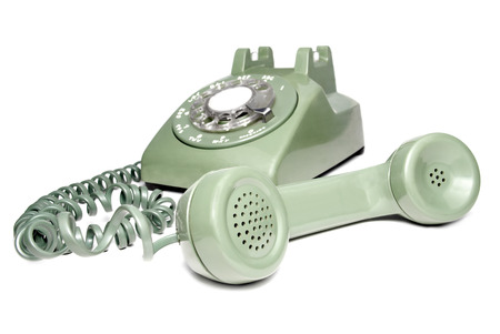 Picture of antique retro green rotary telephone with receiver off the hook on a white background.の写真素材