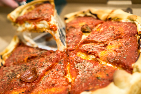 Deep Dish Pizza with a slice being pulled and cheese hanging. Copyright © Paul Velgos with All Rights Reserved.の写真素材