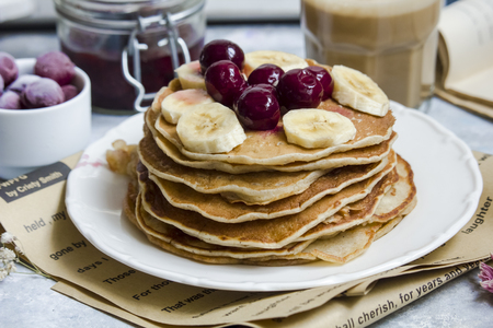 Pancakes with banana on the top and a cup of coffeeの写真素材