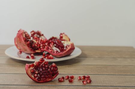 pomegranate on the backgraund, pomegranate slice in front and fallen pomegranate