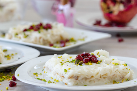 Traditional Ramadan Dessert Gullac on the table. It is made with gullac, milk, rose water, walnut, vanilla. It is decorated with pomegranate  and pistachio.の写真素材