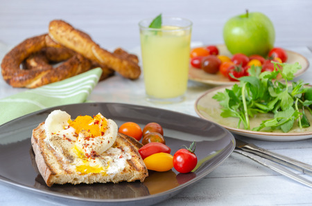 Turkish breakfast with eggs, toasted bread, bagel, lemonade, green apple,tomatoes, parsley and mint,...