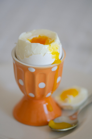 Boiled egg for breakfast in a orange eggcup.