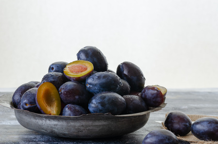 Damson plums are in the ancient copper cup .