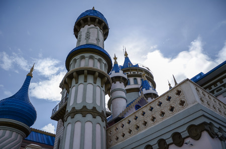 Close up view of fairytale castle in park on cloudy background.