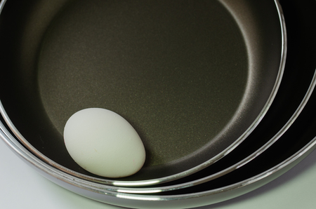 One egg in three pans,black background.の写真素材