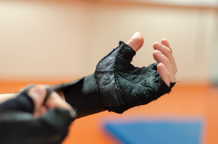 Sportsman is wearing fitness gloves in gym.の写真素材