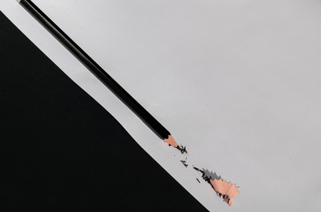 Black Pencil With Shaving Isolated On White and black Background. Macro Photography. Top View.の写真素材