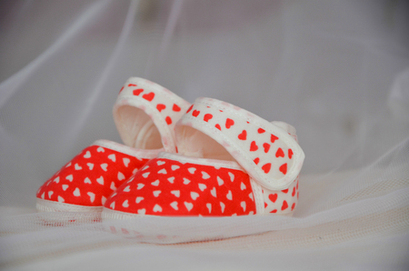 Red-white baby booties are  on the cribの写真素材