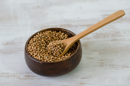 Coriander seeds in a wooden bowlの写真素材