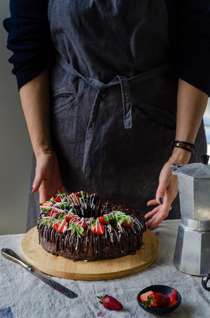 Woman brings strawberry cake to the table.の写真素材