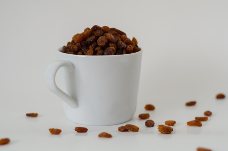Bowl with dried raisins isolated on white background , top view. Healthy nutrition with fruitsの写真素材
