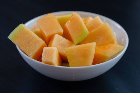 melon slices in white plate on black background.の写真素材