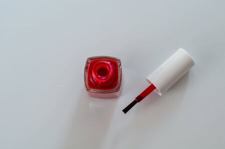 A red nail polish bottle and brush on the white background,top view.の写真素材