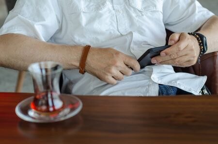 Man is looking on smartphone at the cafe