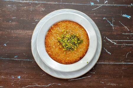 Delicious traditional Turkish dessert:  Kunefe  kadayif with pistachio and cheeseの写真素材