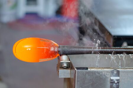 Glass blower manufacturing process, moment of cooling the glass  at a glass makers workshopの写真素材