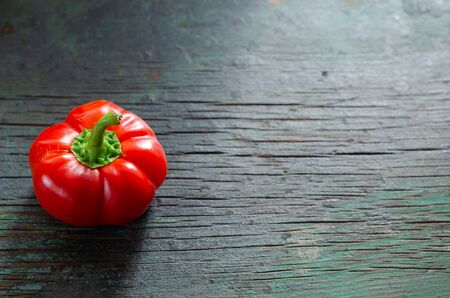Red bell pepper on the wooden table.
