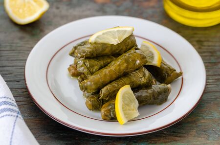 Traditional Turkish Dolma, Sarma or Dolmades,  Eating Traditional Mediterranean Dish Dolmadakia or Stuffed Grapes Leaves on Rustic Backgroundの写真素材