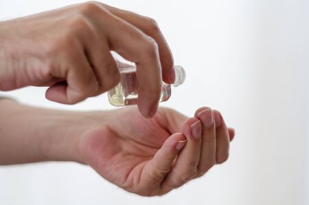 The man is pouring eau de Turkish Lemon Cologne to his hand and disinfecting the hand and killing the virusesの写真素材