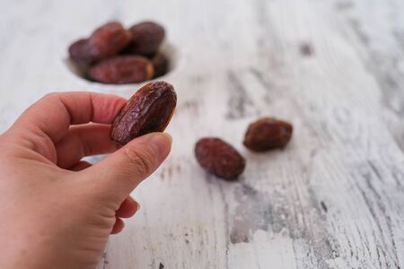 Ripened dates are  in the bowl and her hand . An important fruit in islamic country.  A healthy and...