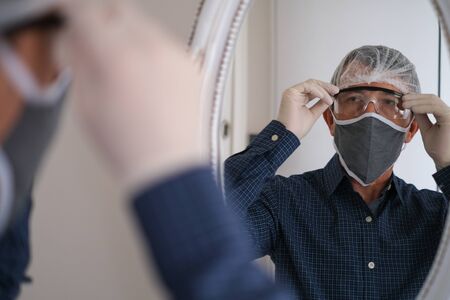 Middle-aged man wears hygienic mask to prevent infection airborne respiratory disease such as...