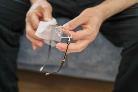 The man is cleaning his glasses for sanitize in corona pandemic days.の写真素材