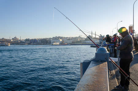 ISTANBUL, TURKEY - January 25, 2020:  Fishermen  are catching  fish at Galata Bridge. Golden Horn in  Istanbul, Turkeyのeditorial素材