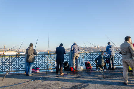 ISTANBUL, TURKEY - January 25, 2020:  Fishermen  are catching  fish at Galata Bridge. Golden Horn in  Istanbul, Turkeyのeditorial素材